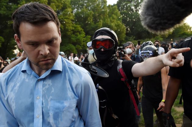 Far-right pro-Trump propagandist and One America News correspondent Jack Posobiec is escorted out of...