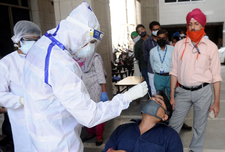 PATIALA, INDIA - SEPTEMBER 11: Health workers wearing PPE kit conduct COVID-19 Rapid Antigen test of SBI bank employees, on September 11, 2020 in Patiala, India. (Photo by Bharat Bhushan/ Hindustan Times)