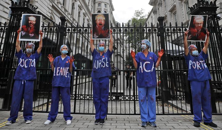 Nurses stand in front of the entrance to Downing Street as they take part in a demonstration of NHS workers at hospitals across London to demand a 15 per cent pay rise by the government in London, Wednesday, Aug. 26, 2020.(AP Photo/Kirsty Wigglesworth)