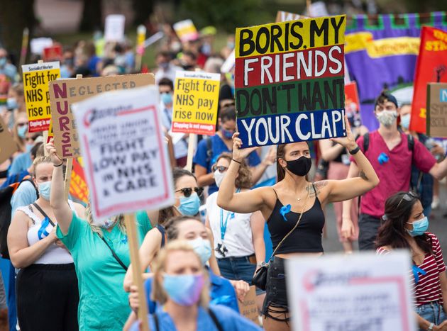 National Health Service (NHS) workers march from St. James' Park to Downing Street, London,  Saturday Aug. 8, 2020, as part of a national protest over pay. Nationwide protests on Saturday are calling for government to address what they claim is many years of reduced wages, and are calling for a voice in plans for public sector pay increases. (Dominic Lipinski/PA via AP)