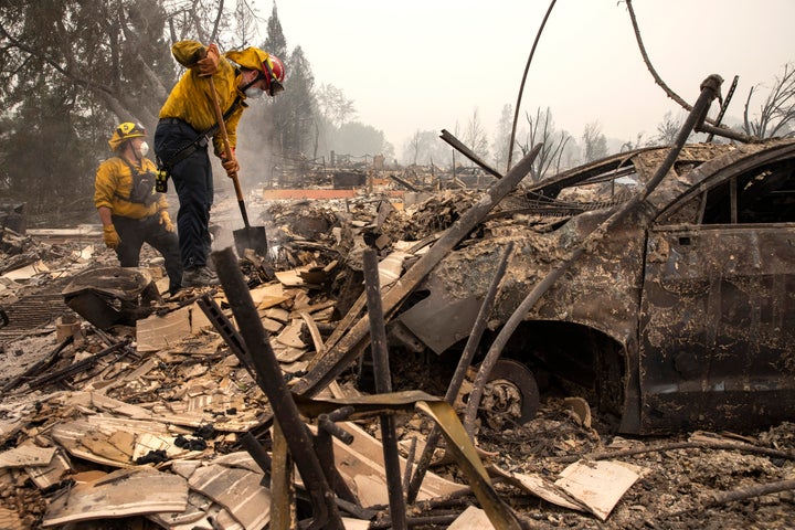 Jackson County District 5 firefighter Captain Aaron Bustard, right, and Andy Buckingham work on a smoldering fire in a burned neighborhood in Talent, Ore., Friday, Sept. 11, 2020, as destructive wildfires devastate the region. 