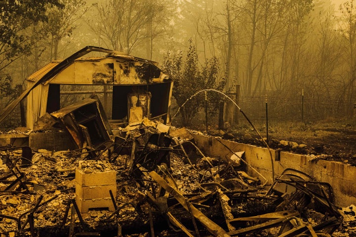 Water continues to flow from a pipe amid the charred remains of homes and businesses after the passage of the Santiam fire in Gates, Oregon, on Sept. 10.