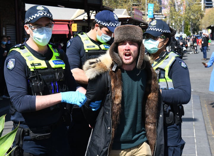 Police detain an anti-lockdown protester at Melbourne's Queen Victoria Market.