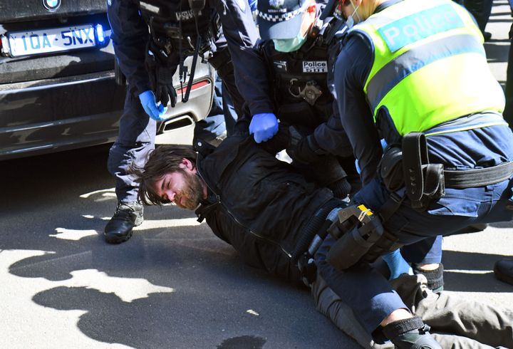 Police detain an anti-lockdown protester at Melbourne's Queen Victoria Market.