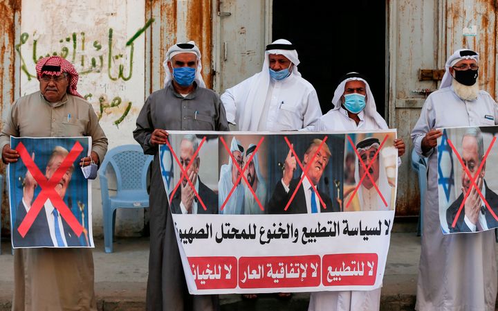 Παλαιστίνιοι με αφίσες, στις οποίες εμφανίζονται ο Βασιλιάς του Μπαχρέιν, ο πρόεδρος των ΗΠΑ και ο ισραηλινός πρωθυπουργός, διαμαρτύρονται για τη συμφωνία μεταξύ Ισραήλ - Μπαχρέιν