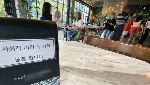 On the 13th, when the social distancing step in the metropolitan area was adjusted from step 2.5 to step 2 for two weeks, a cafe on a street of cafes in central Seoul was filled with citizens.