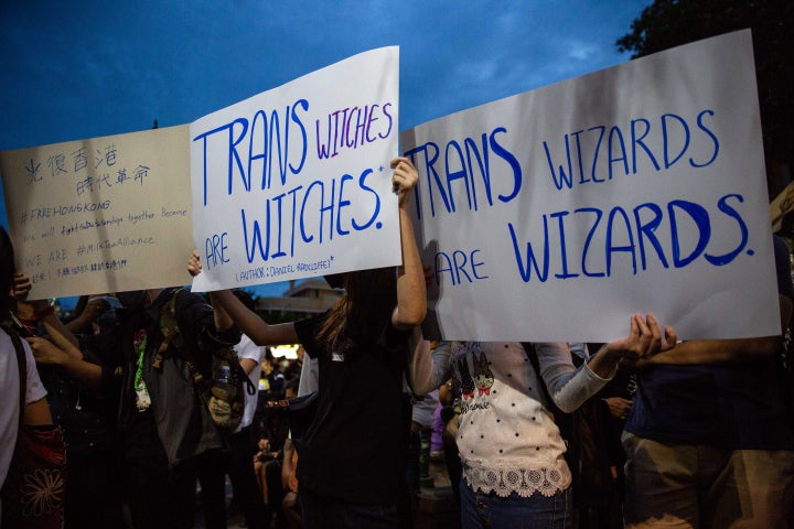 Anti-government protesters in Bangkok hold signs calling out J.K. Rowling's transphobic Twitter comments as they take part in a Harry Potter themed rally in front of Democracy Monument on Aug. 3.