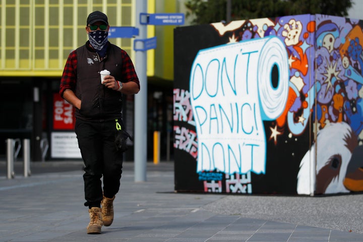 A man wearing a mask walks past street art in Prahran on September 14, 2020 in Melbourne, Australia. 