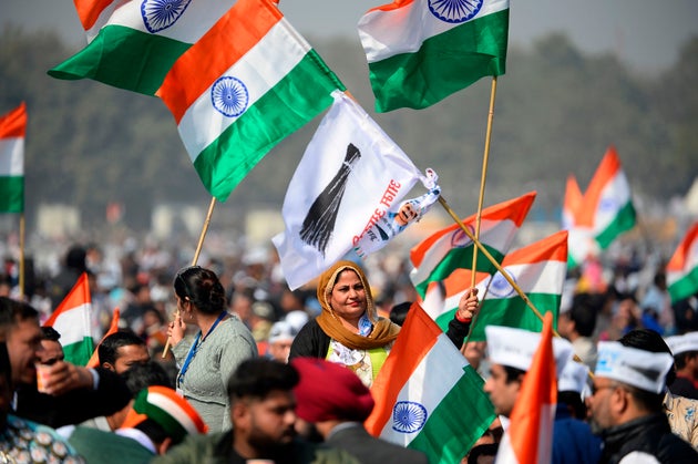 Supporters of the Aam Aadmi Party (AAP) hold party flags and Indian national flags before Arvind Kejriwal...
