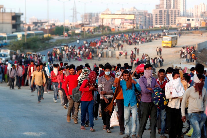 Migrant workers walk towards a bus station along a highway with their families as they return to their villages, during a 21-day nationwide lockdown to limit the spreading of coronavirus disease (COVID-19), in Ghaziabad, on the outskirts of New Delhi, March 29, 2020. 