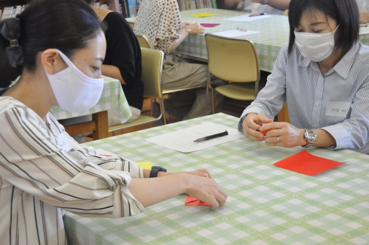 「鶴は『リボンなし』が折っても大丈夫かな」などと話しながら折り紙をする参加者