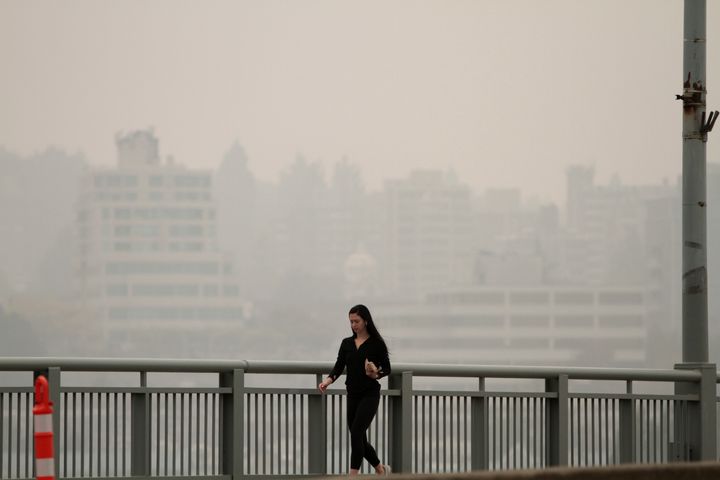 A woman walks on Granville Bridge as smoke from wildfires fills the air in Vancouver, B.C. on Sept. 12, 2020. 