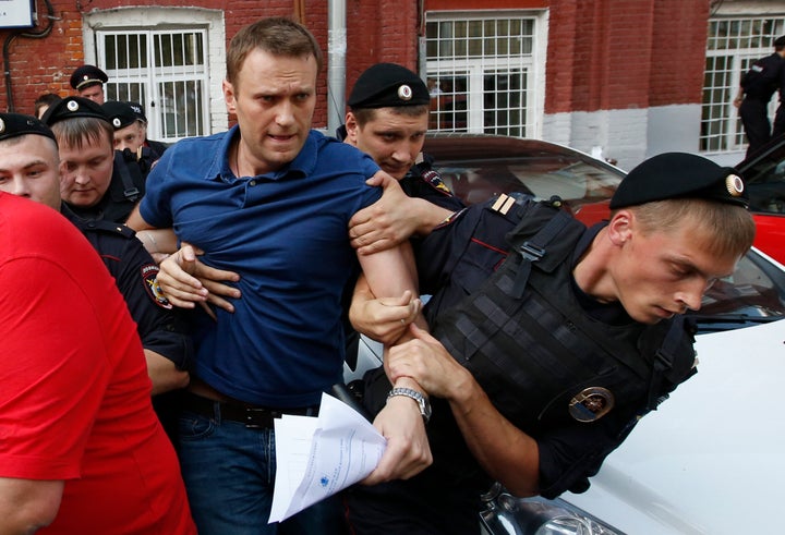 Navalny, who has vowed to destroy the political system under President Vladimir Putin, is seen being detained by police in 2013 after he visited Moscow's election commission office to submit documents to get registered as a mayoral election candidate. 