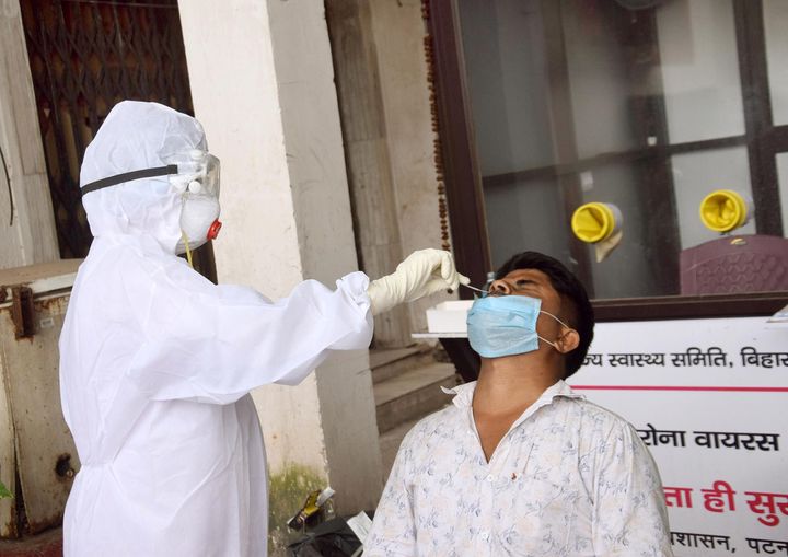 A health worker collects a swab sample from a man for coronavirus testing, at Gardiner Hospital, on August 26, 2020 in Patna.
