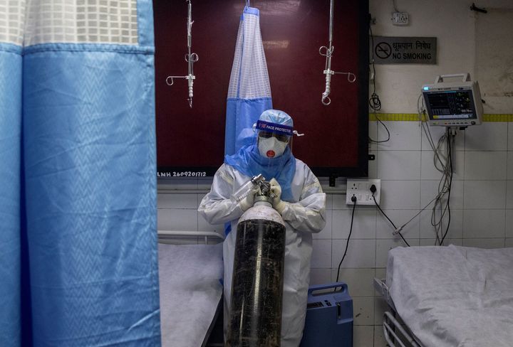 A medical worker wearing PPE pushes an oxygen cylinder at the casualty ward in Lok Nayak Jai Prakash (LNJP) hospital, in New Delhi, July 17, 2020. 
