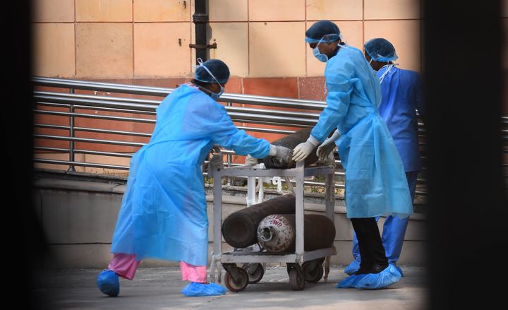 Medical workers draw a cart with oxygen cylinders outside the Covid-19 ward, at Lok Nayak Jai Prakash Narayan Hospital, on July 1, 2020 in New Delhi.