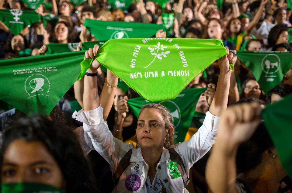 Mulheres erguem lenços da cor verde, símbolo da luta pela discriminalização...
