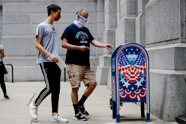 Benjamin Graff (center) and son Jacob Graff, 19, drop off their mail-in ballots for the Pennsylvania primary election in Phil