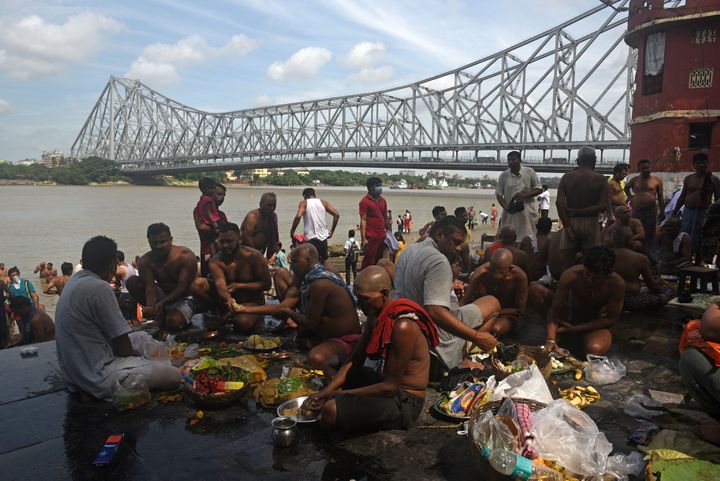 Devotees perform rituals on the bank of river Hooghly to mark the occasion of Mahalaya, at Jagannath Ghat, near Howrah Bridge on September 17, 2020 in Kolkata, India. 