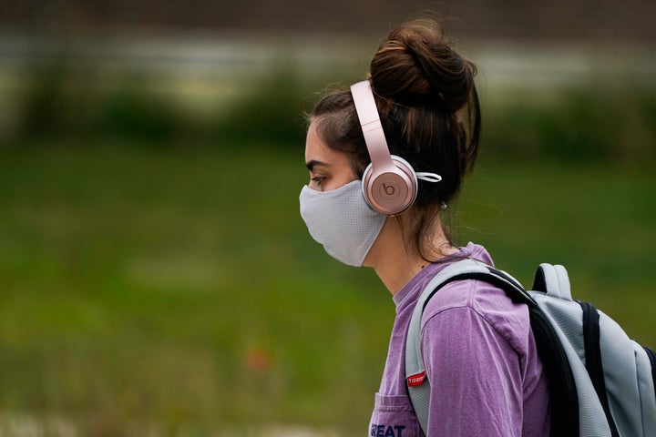 A masked student walks through the campus of Ball State University in Muncie, Ind., Thursday, Sept. 10, 2020. 