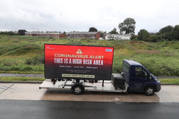 A mobile advertising vehicle displaying a coronavirus high risk area warning in Oldham, Greater Manchester