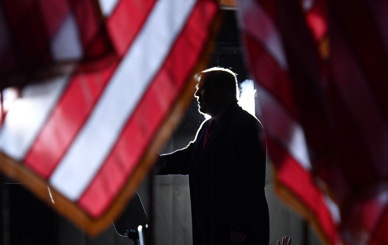 Donald Trump is seen behind US flags as he speaks to supporters Mosinee, Wisconsin.
