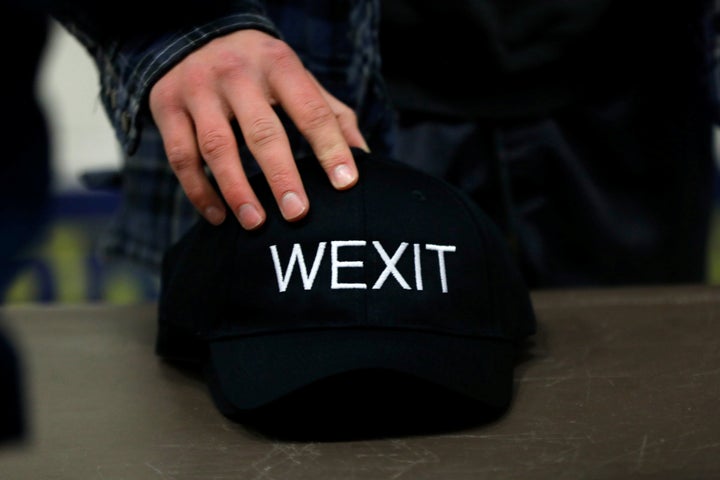 A supporter holds his Wexit hat while attending a rally in Calgary on Nov. 16, 2019.