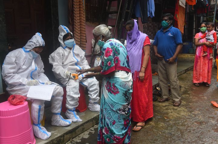 BMC Health worker and Doctor conduct thermal screening and pulse test of a resident at Dharavi during Covid 19 pandemic, on August 11, 2020 in Mumbai, India.
