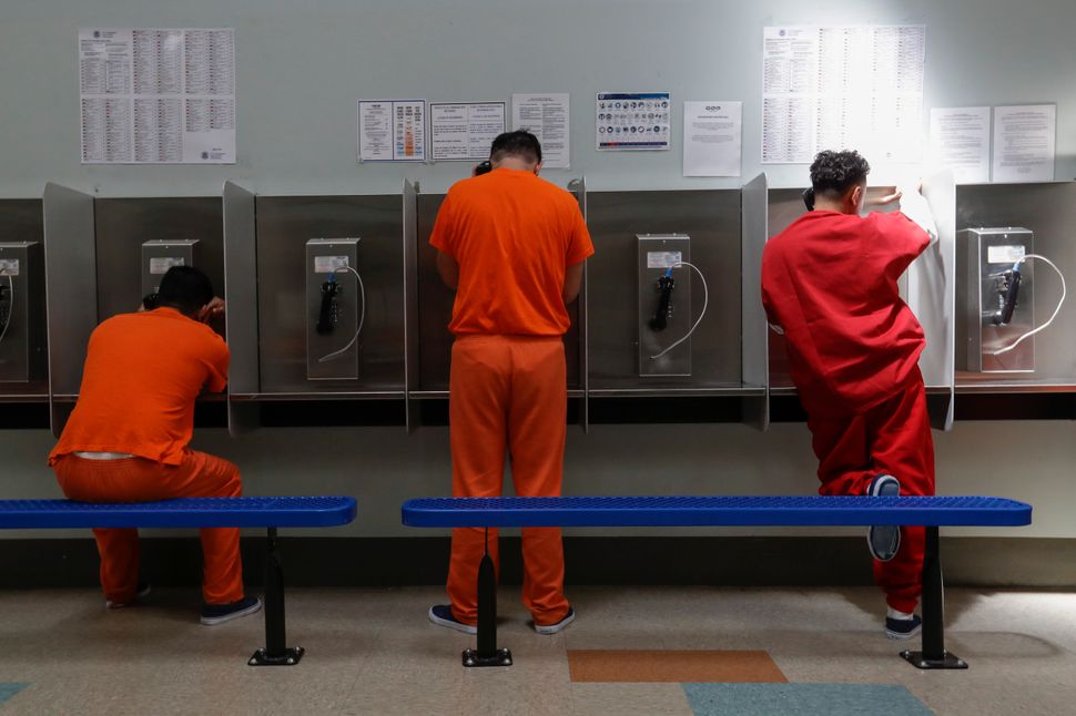 Des détenus parlent au téléphone dans un centre de traitement d'ICE à Adelanto, en Californie, le 28 août 2019.