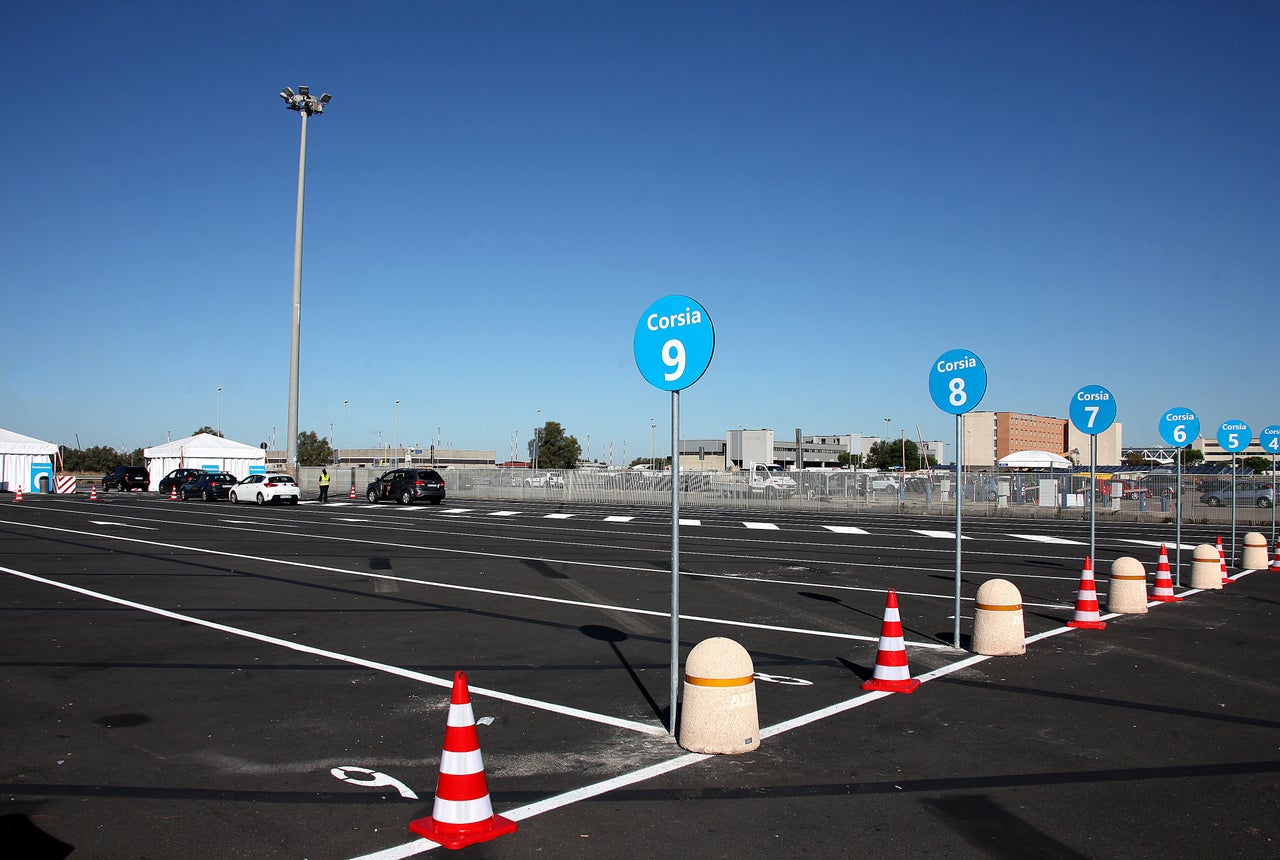 People in cars line up to be tested for COVID-19 at a drive-through testing center at a parking area of Rome's Leonardo da Vinci international airport in Fiumicino. In Italy, people must receive a doctor’s prescription in order to get a test, unless they are a designated key worker.