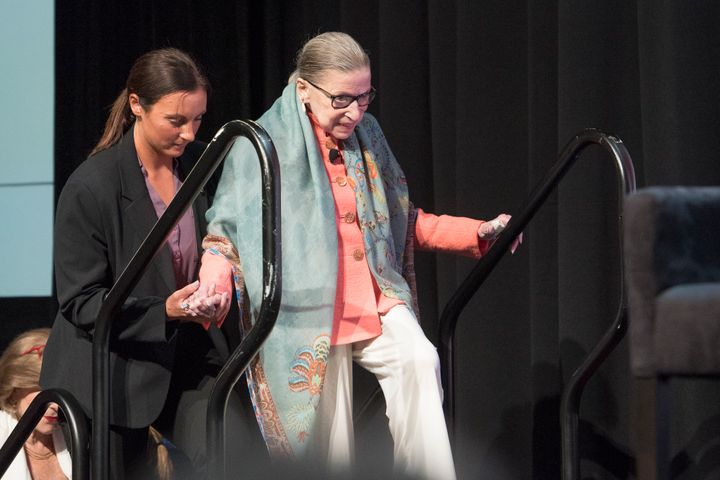 Supreme Court Associate Justice Ruth Bader Ginsburg is aided by a member of her security detail, as she walks up a set of stairs to the stage, to speak at the Library of Congress National Book Festival in Washington, Saturday, Aug. 31, 2019. (AP Photo/Cliff Owen)