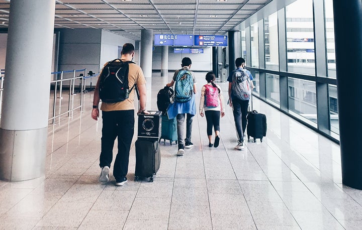 The Nelson family navigate one of many airport stops on their two-week commute home from Saudi Arabia under Australia's strict arrivals cap.