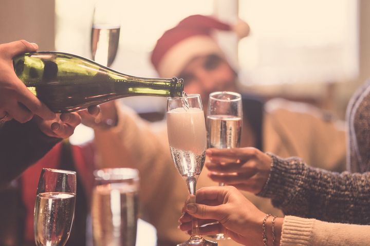 Cropped image of people toasting with champagne celebrating Christmas