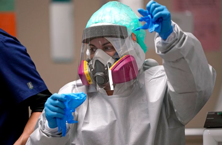 A registered nurse makes her way to a patient's room inside the coronavirus unit at Houston's United Memorial Medical Center. If the coronavirus is airborne, as many scientists say it is, health experts urge the use of masks and air filtration systems to help prevent virus transmission.