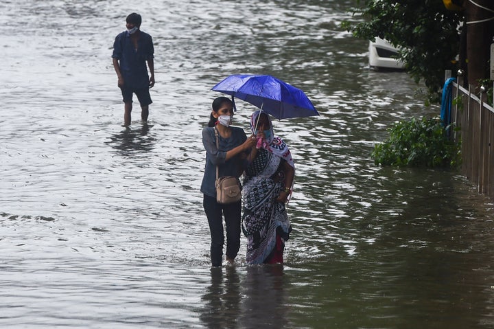 People wade through a flooded street in Mumbai on September 23, 2020.