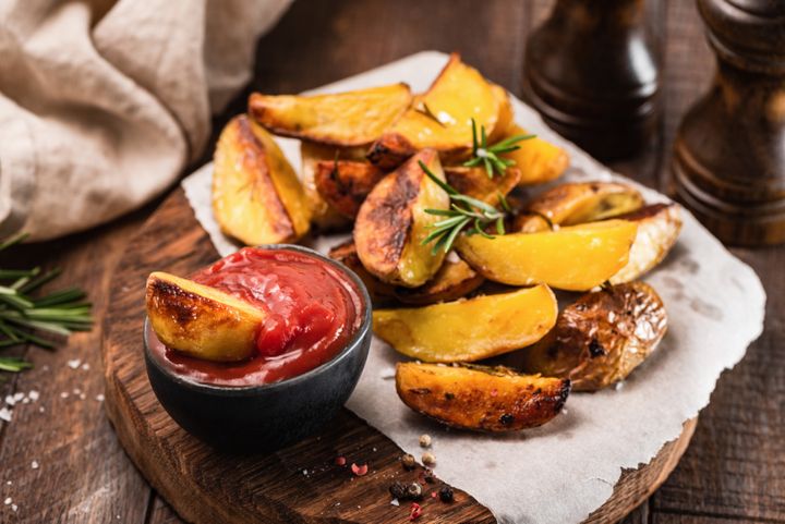 Chunky baked potato wedges with ketchup.