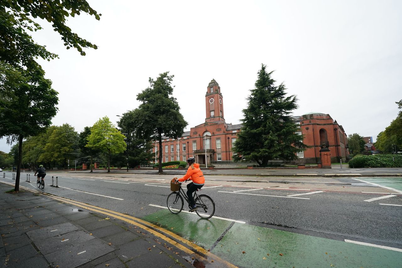 A person cycles past Trafford Town Hall in Greater Manchester