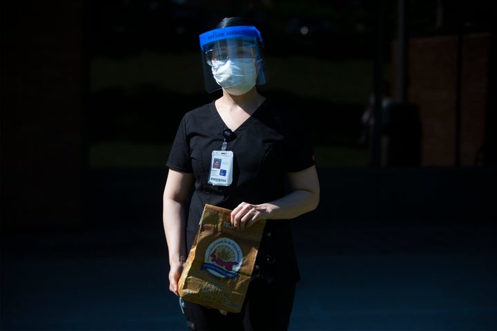 Registered Nurse Shekiba Khedri holds a bagged gift from Prince Edward Island handed out by Ontario Premier Doug Ford to health-care workers at Birchmount Hospital in Toronto on Monday, June 8, 2020.