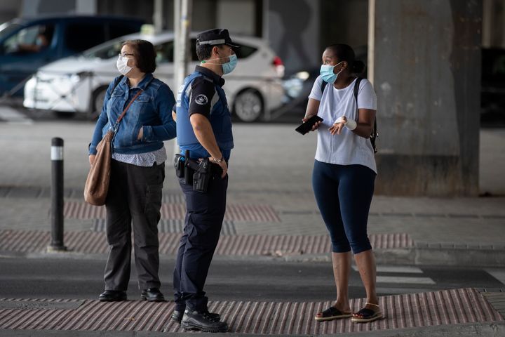A local police officer talks with a woman at a checkpoint in the Vallecas neighborhood in Madrid, Spain, on Wednesday.