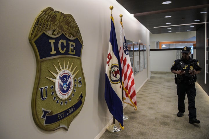 A law enforcement officer walks past ICE logo ahead of a press conference on May 11, 2017.
