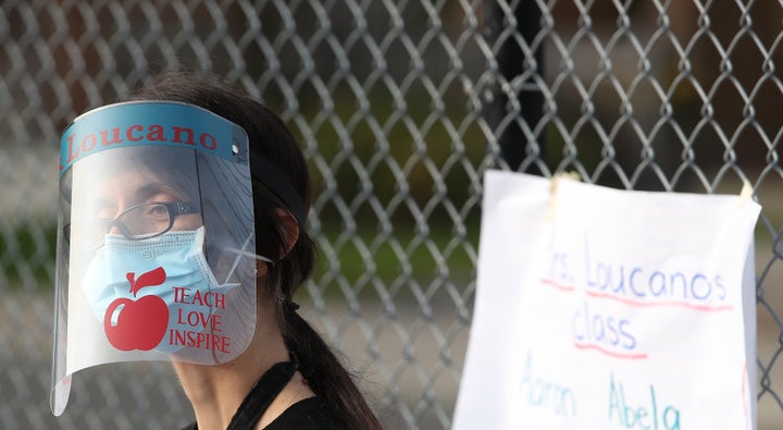 A teacher greets students at Our Lady of Lourdes Catholic School in Toronto on Sept. 14, 2020.