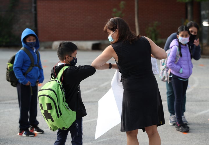 A teacher greets a student at Our Lady of Lourdes Catholic School in Toronto.