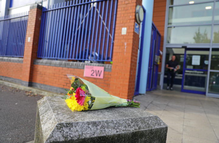 A bouquet of flowers is left at the scene where the office was shot 