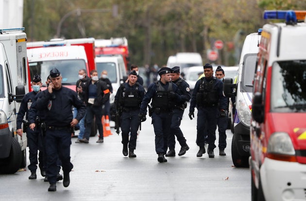 French police officers patrol after four people were wounded in a knife attack near the former offices of satirical newspaper Charlie Hebdo