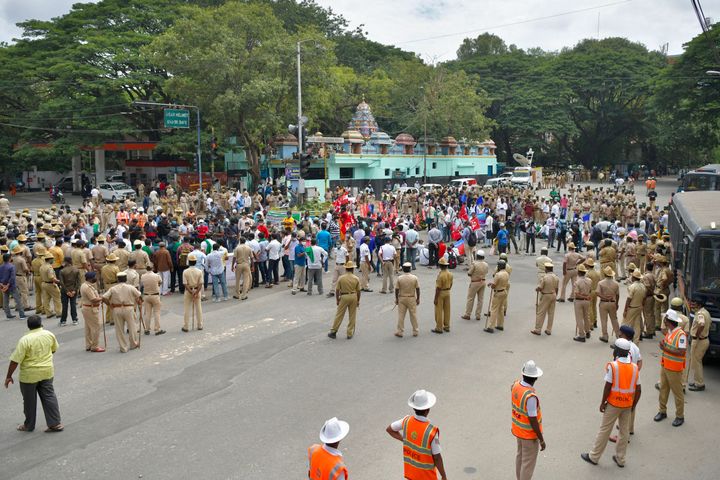 Police personnel stand guard as farmers' organisations stage a protest following in Bengaluru. 