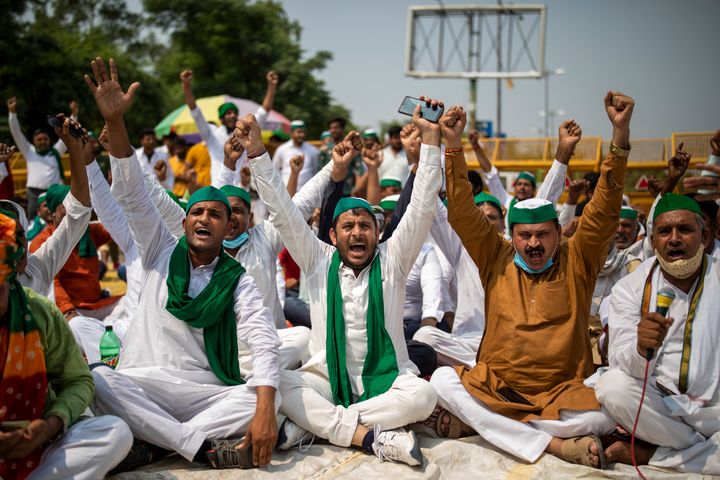 Farmers shout slogans as they block a highway during a protest in Noida against new farm bills.