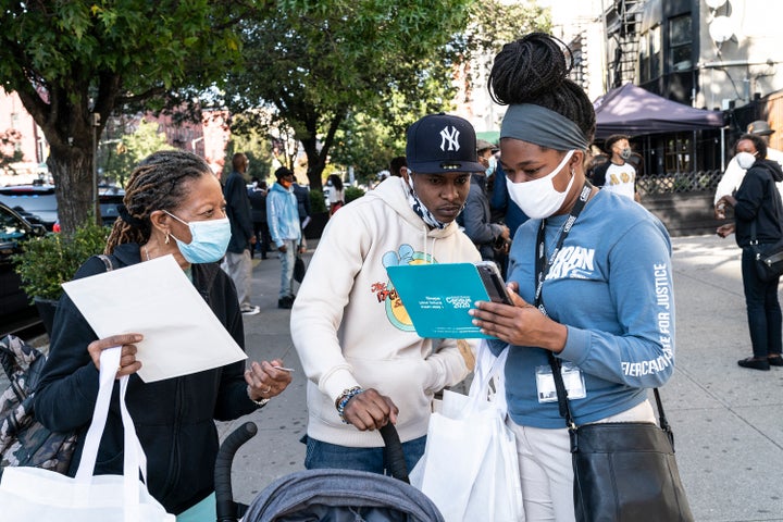 Census 2020 employees help residents fill out the 2020 census form at Sylvia's Restaurant in New York City's Harlem. On Thursday, a federal judge ruled that the census must continue through October to prevent an undercount. (Photo by Lev Radin/Pacific Press/LightRocket via Getty Images)