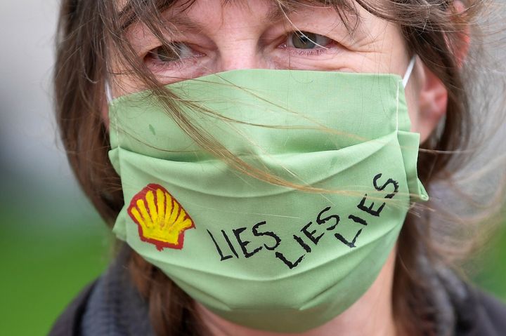 A slogan is seen on a protective face mask of an Extinction Rebellion climate action group protester as she demonstrates agai