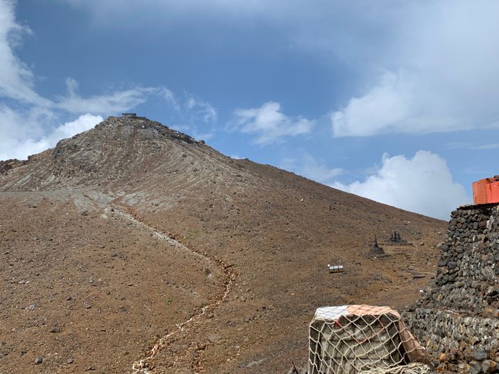 王滝山頂から奥の剣ヶ峰山頂までの「八丁ダルミ」を含む付近は開けており、身を隠す場がほとんどない。噴火口は左手にあり、噴火して間もなく噴石が落ちてきたという＝2020年8月22日
