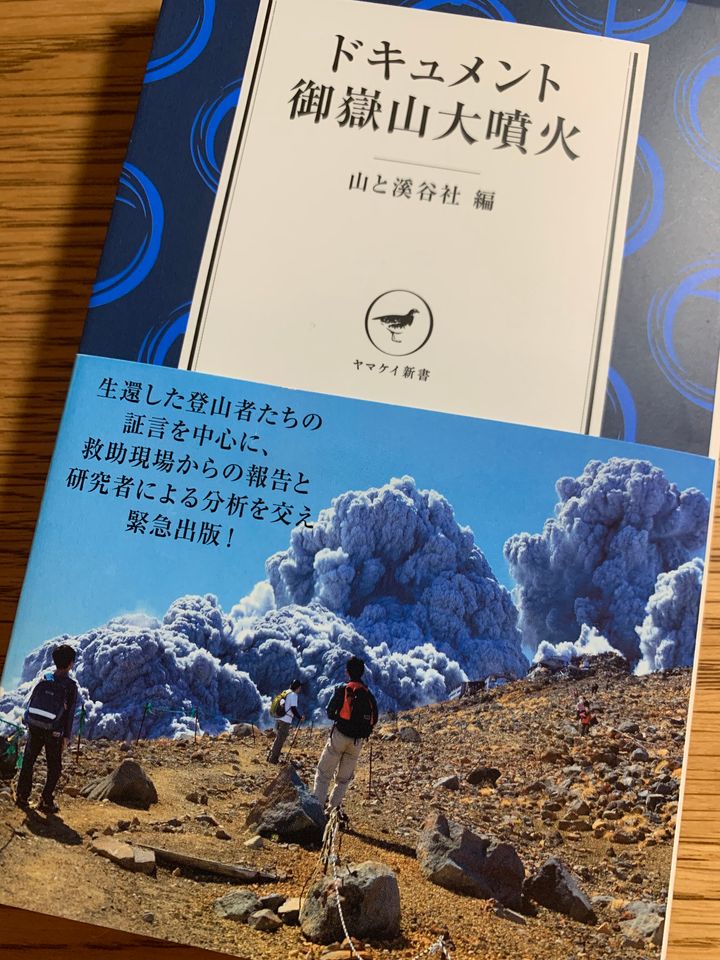 『ドキュメント御嶽山大噴火』の表紙。登山者が撮影した噴火直後の写真には、噴煙を見上げ立ちすくむ人たちが写っている